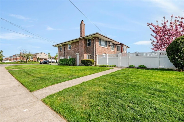 view of home's exterior featuring a yard, brick siding, fence, and a chimney