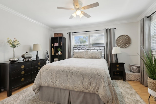 bedroom with light wood-type flooring, a ceiling fan, and crown molding