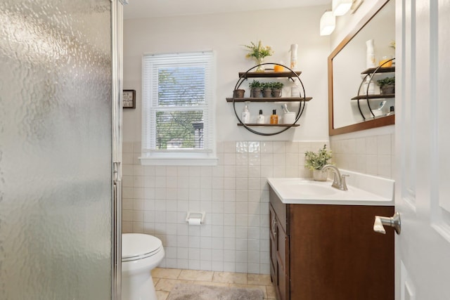 full bathroom with tile walls, wainscoting, a stall shower, vanity, and toilet