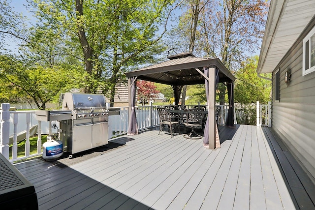 deck featuring a gazebo, a grill, and outdoor dining space