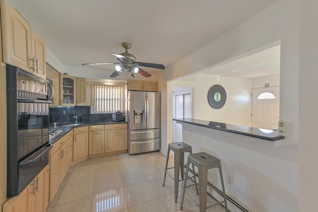 kitchen with light brown cabinetry, dark countertops, oven, stainless steel fridge with ice dispenser, and a warming drawer