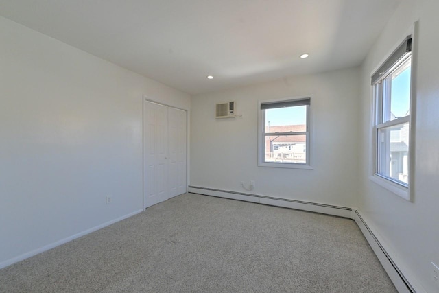 spare room with light colored carpet, recessed lighting, and a baseboard heating unit