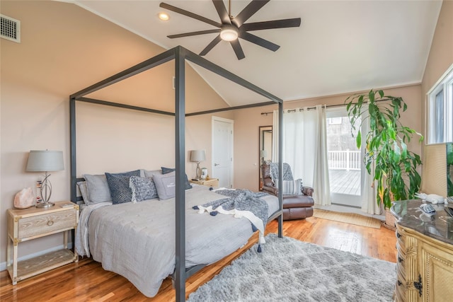 bedroom featuring wood finished floors, access to outside, visible vents, and lofted ceiling
