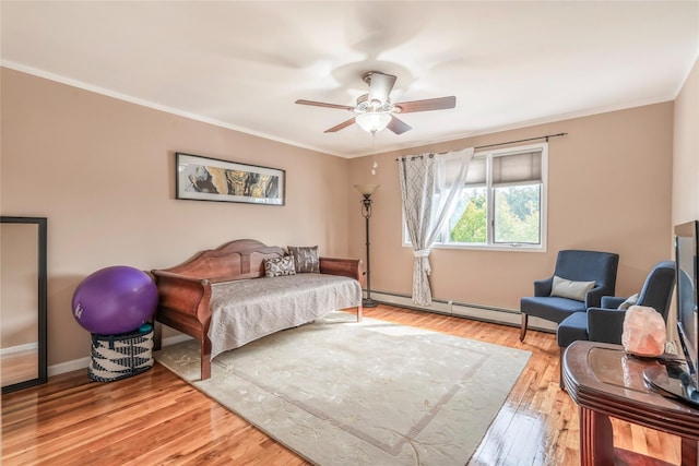 bedroom featuring crown molding, ceiling fan, light wood-style flooring, baseboards, and a baseboard heating unit