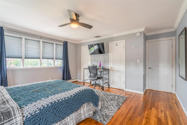 bedroom with baseboards, visible vents, ornamental molding, and wood finished floors