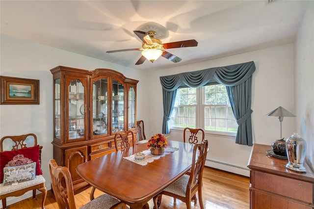 dining space featuring baseboard heating, a ceiling fan, and light wood finished floors