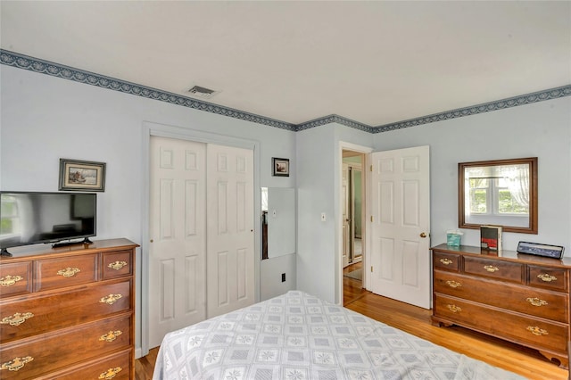 bedroom with visible vents, a closet, and light wood-type flooring