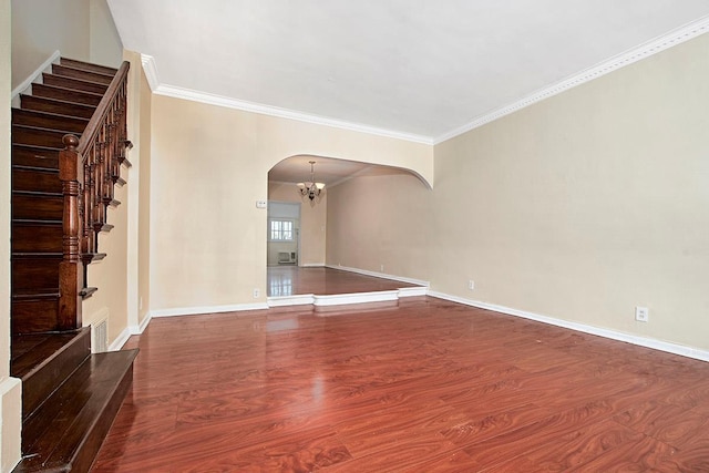 unfurnished living room with an inviting chandelier, crown molding, wood finished floors, stairway, and arched walkways