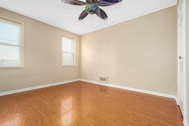 unfurnished room with visible vents, baseboards, ceiling fan, and wood finished floors