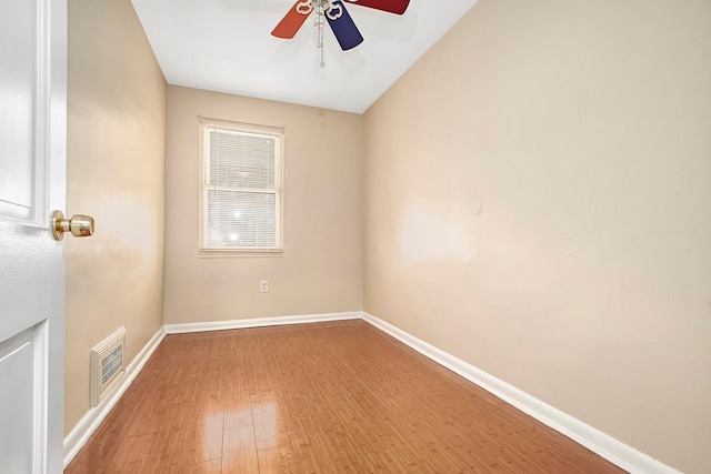 spare room featuring baseboards, ceiling fan, wood finished floors, and visible vents