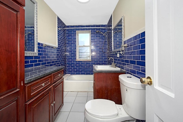 bathroom featuring tile walls, vanity, a bathing tub, tile patterned floors, and toilet