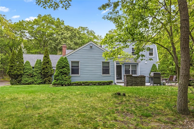 7 E Gate Ln, Setauket, NY 11733 - back of house featuring a lawn, a shingled roof, and a chimney