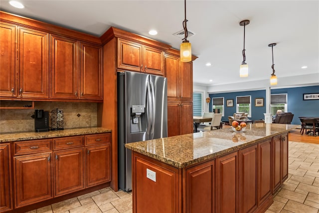 7 E Gate Ln, Setauket, NY 11733 - kitchen featuring stainless steel fridge with ice dispenser, decorative backsplash, hanging light fixtures, stone countertops, and a kitchen island