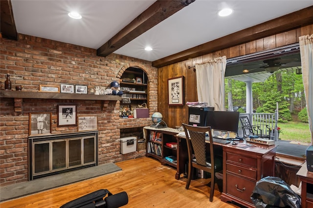 7 E Gate Ln, Setauket, NY 11733 - home office featuring a fireplace, beam ceiling, wood finished floors, a ceiling fan, and wood walls