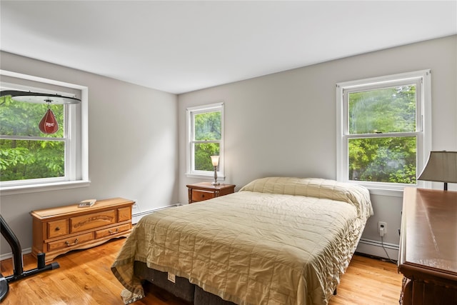 7 E Gate Ln, Setauket, NY 11733 - bedroom with a baseboard heating unit and light wood-style floors