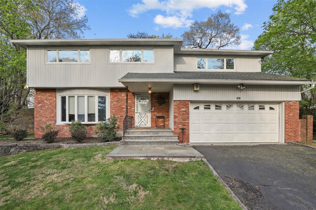 69 Price St, Dobbs Ferry, NY 10522 - view of front of home with a garage, a front yard, driveway, and brick siding