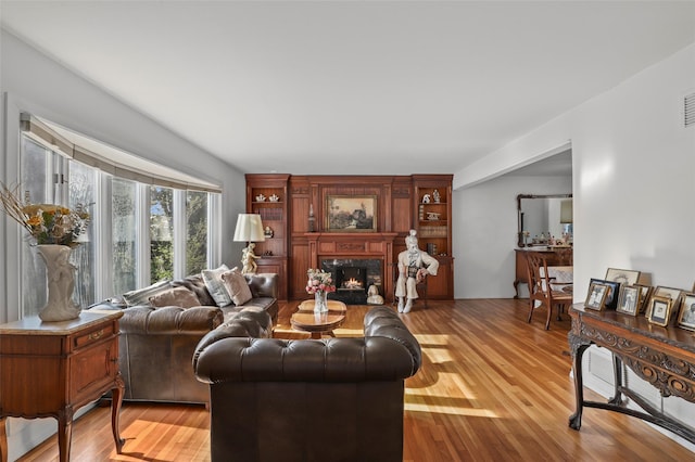 living room featuring visible vents, wood finished floors, and a fireplace