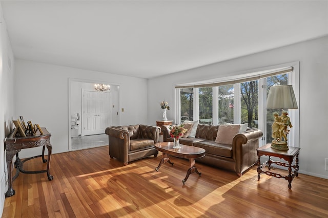 living room featuring visible vents, wood finished floors, and a notable chandelier