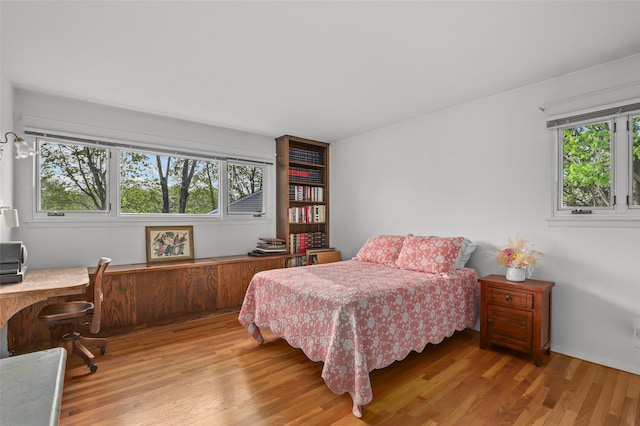bedroom featuring multiple windows and wood finished floors