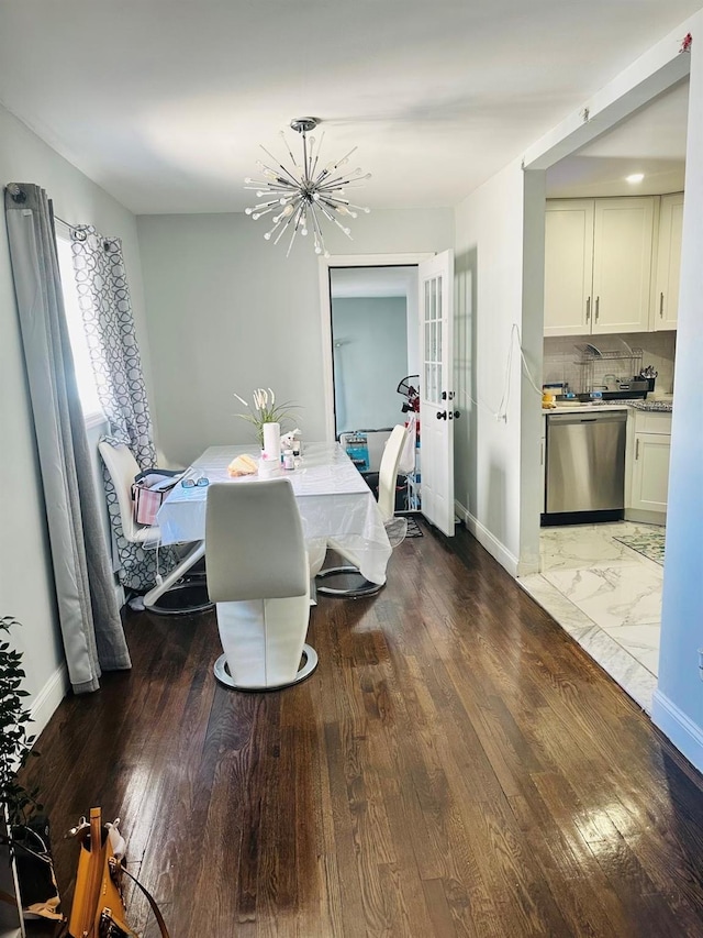 dining area with baseboards, wood finished floors, a chandelier, and french doors
