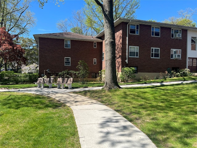 townhome / multi-family property with brick siding and a front yard
