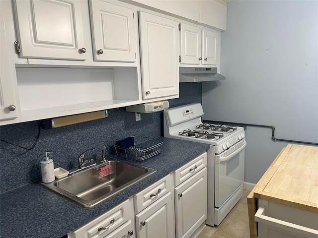 kitchen featuring white range with gas stovetop, white cabinetry, under cabinet range hood, a sink, and backsplash
