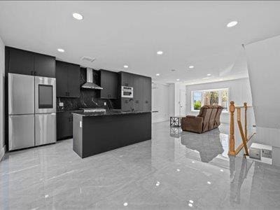 66-39 Jay Ave, Maspeth, NY 11378 - kitchen featuring wall chimney range hood, dark countertops, dark cabinets, marble finish floor, and smart refrigerator