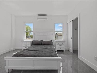66-39 Jay Ave, Maspeth, NY 11378 - bedroom with baseboards and a wall mounted air conditioner