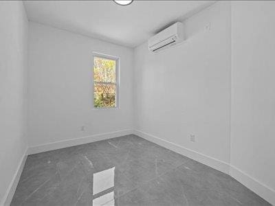 66-39 Jay Ave, Maspeth, NY 11378 - empty room featuring baseboards and a wall mounted air conditioner