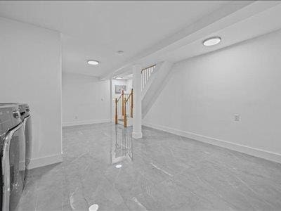 66-39 Jay Ave, Maspeth, NY 11378 - finished below grade area with baseboards, stairs, and independent washer and dryer