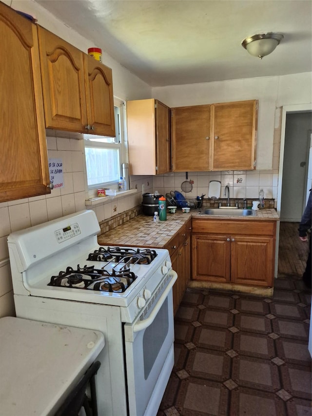 3238 Tenbroeck Ave, Bronx, NY 10469 - kitchen featuring a sink, backsplash, white range with gas stovetop, and brown cabinets