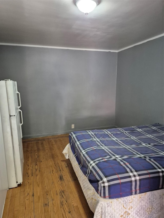 3238 Tenbroeck Ave, Bronx, NY 10469 - bedroom with freestanding refrigerator, ornamental molding, and wood finished floors