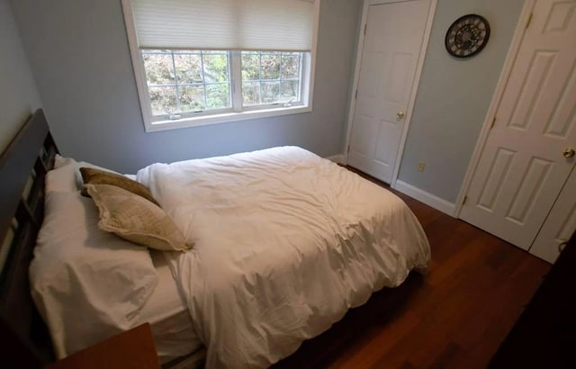 bedroom with baseboards and dark wood finished floors