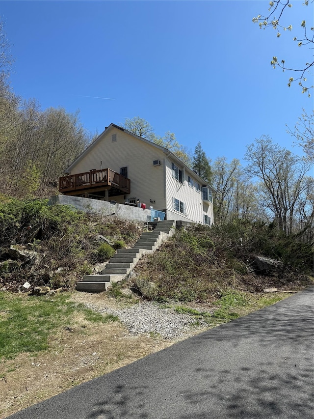 view of side of property featuring stairway and a deck