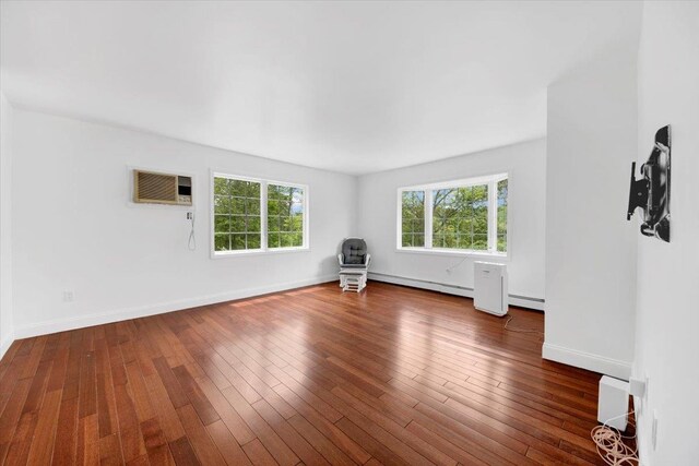 254 Farm To Market Rd, Brewster, NY 10509 - unfurnished living room featuring a wall unit AC, baseboard heating, hardwood / wood-style floors, and a baseboard heating unit