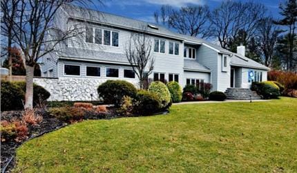 traditional home with a chimney and a front yard