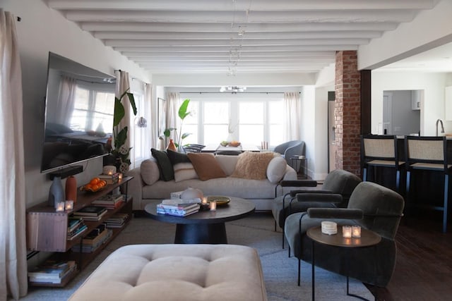 living area with beamed ceiling and wood finished floors