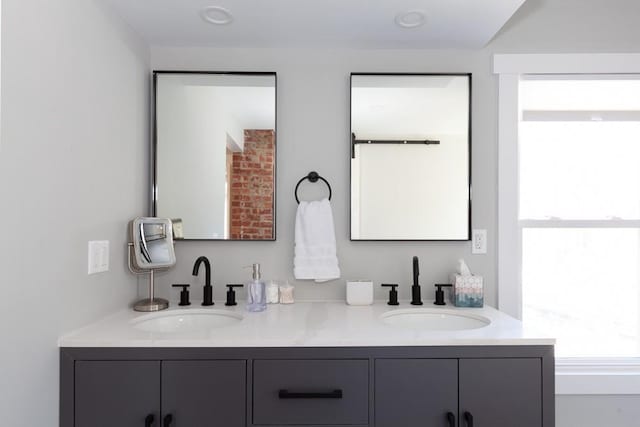 bathroom featuring double vanity, a wealth of natural light, and a sink