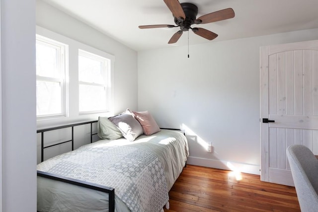 bedroom with baseboards, ceiling fan, and hardwood / wood-style flooring