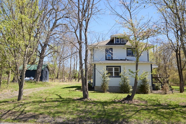 view of side of property featuring a lawn, an outbuilding, and a shed