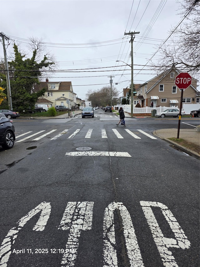 view of street with traffic signs, sidewalks, curbs, and a residential view