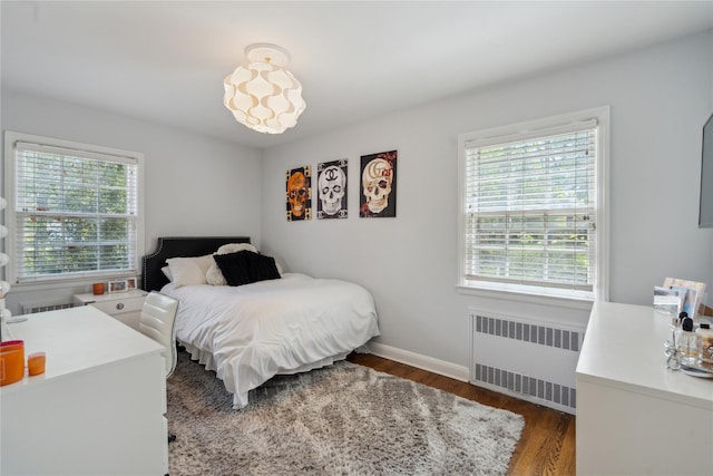 26 Woodgreen Ln, East Hills, NY 11577 - bedroom featuring radiator heating unit, multiple windows, wood finished floors, and baseboards