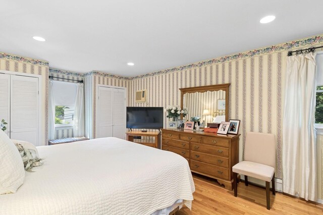 126 Carley Ave, Huntington, NY 11743 - bedroom featuring multiple closets, wood finished floors, wallpapered walls, multiple windows, and recessed lighting