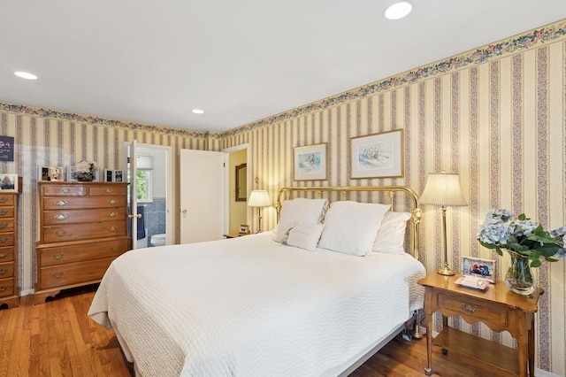 126 Carley Ave, Huntington, NY 11743 - bedroom featuring wood finished floors, wallpapered walls, recessed lighting, and ensuite bath