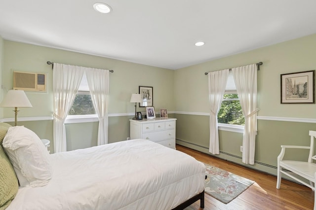 126 Carley Ave, Huntington, NY 11743 - bedroom with a wall unit AC, wood finished floors, and recessed lighting
