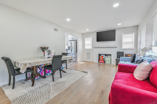 living area with a wealth of natural light, light wood finished floors, and visible vents