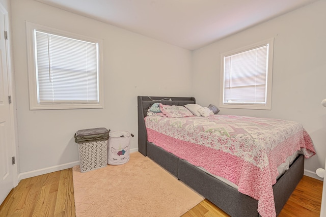 bedroom with baseboards and wood finished floors