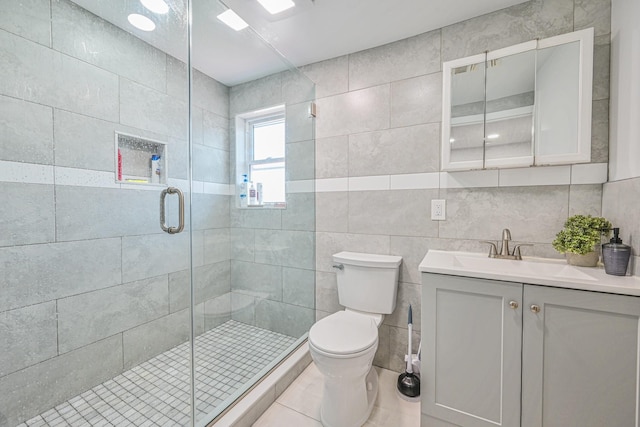 bathroom featuring toilet, tile walls, a shower stall, and vanity