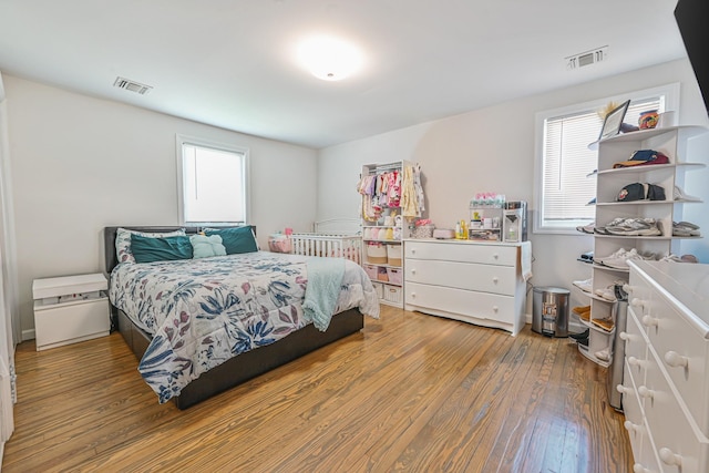 bedroom featuring visible vents and wood finished floors