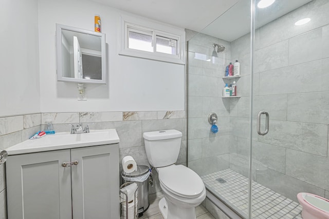 full bath featuring toilet, tile walls, a shower stall, and vanity